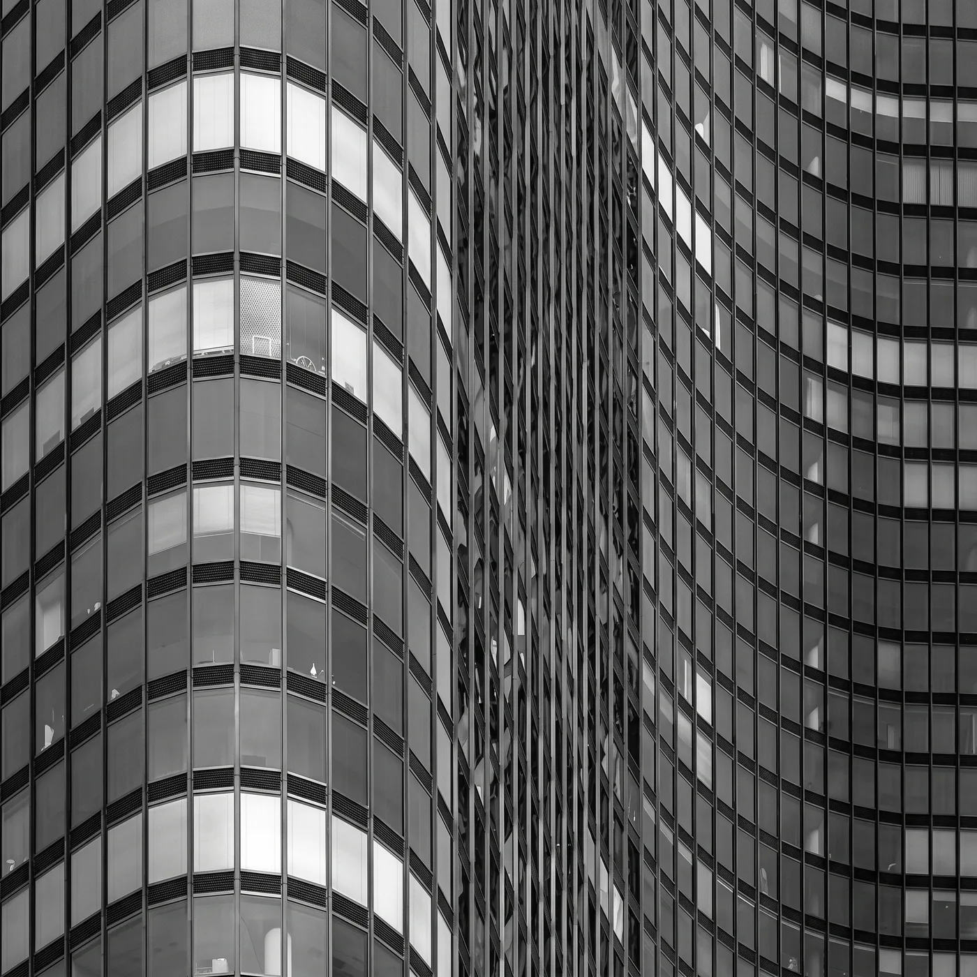 Detalle en blanco y negro de una fachada de vidrio curva de un edificio moderno